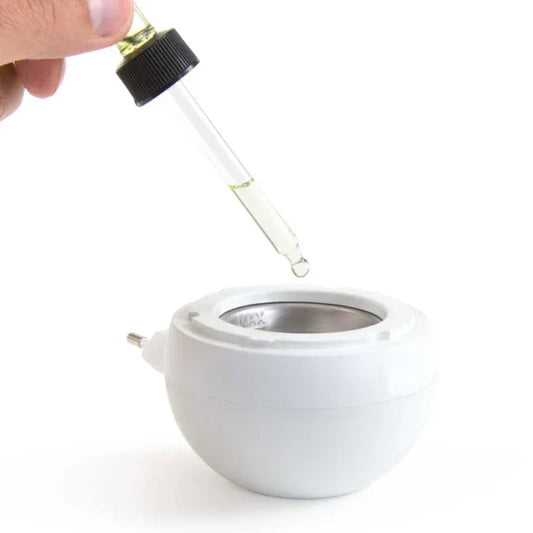 Witte elektrische aromabrander met glazen druppelaar gevuld met olie er boven