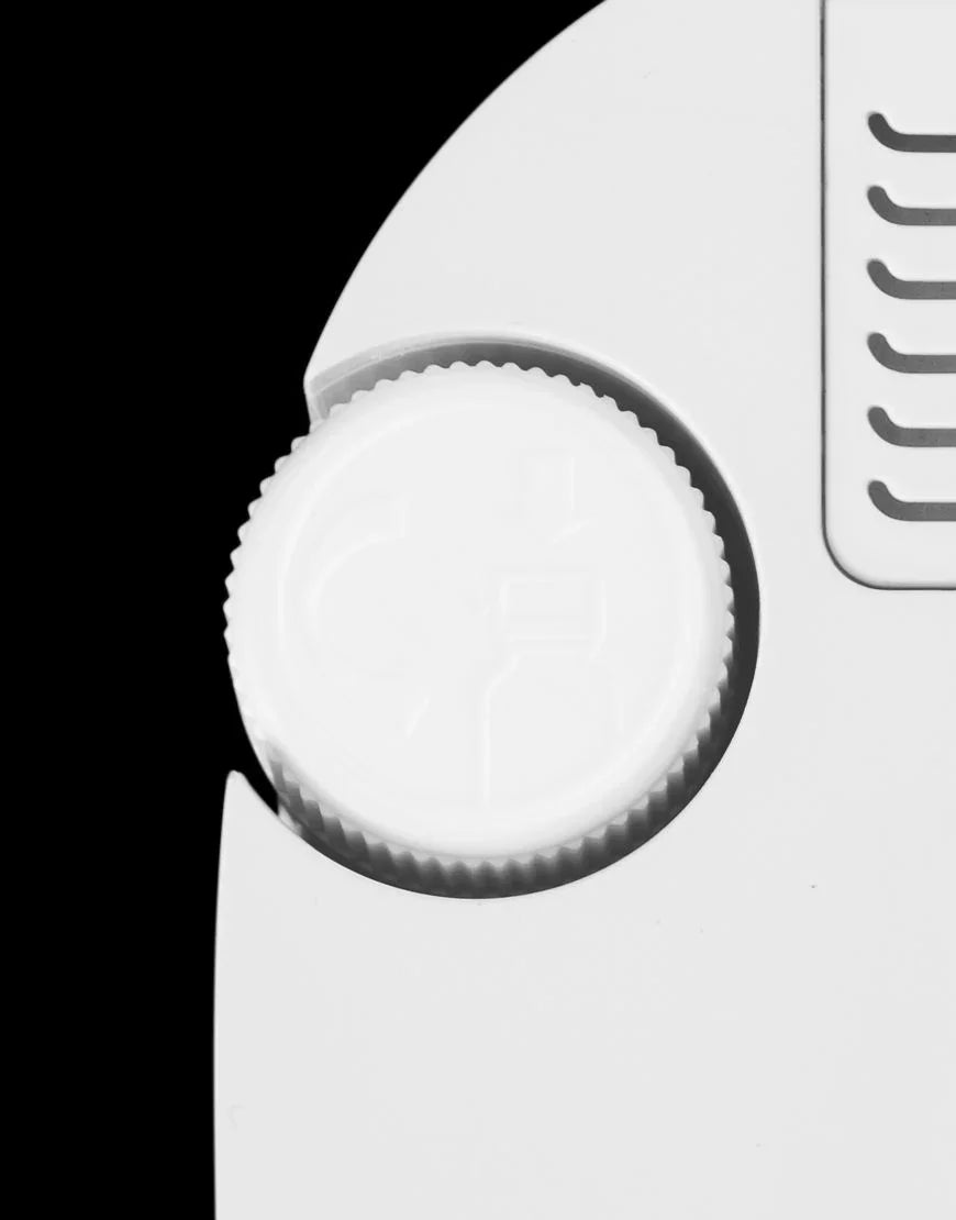 Witte kunststof draaidop met veiligheidspictogram op wit apparaat tegen zwarte achtergrond