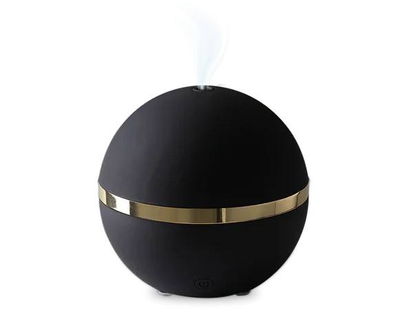 Zwarte bolvormige aromadiffuser met gouden band en stoomafgifte op zwarte achtergrond
