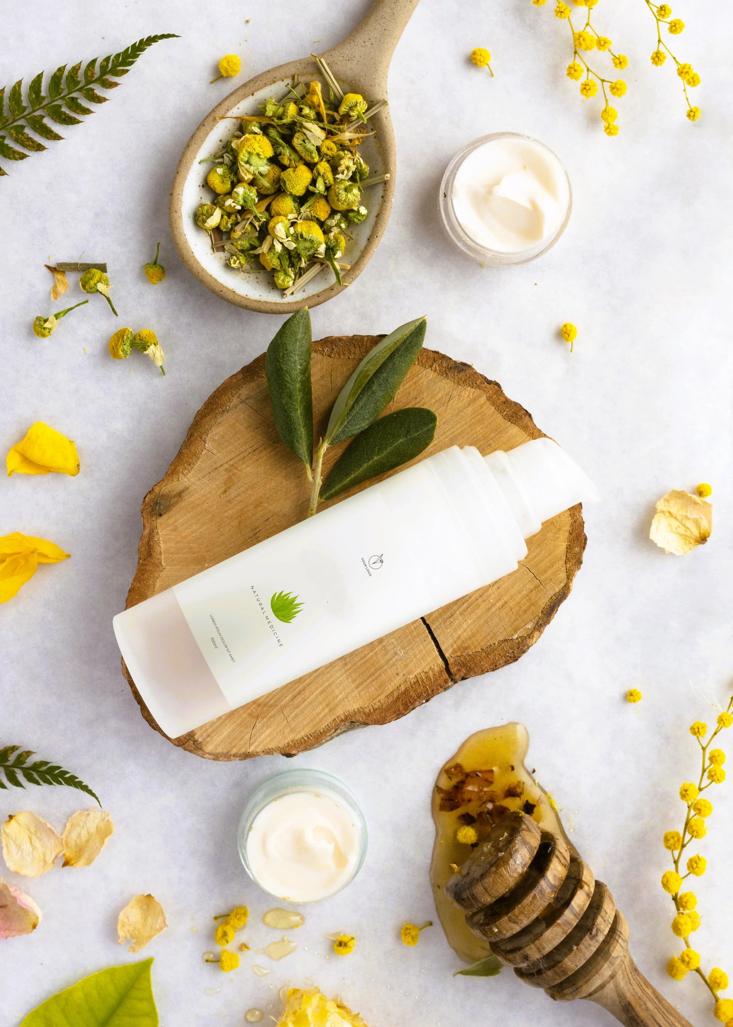 Natuurlijke huidverzorgingsproducten met biologische crème, honing, kamille en groene bladeren op houten plank